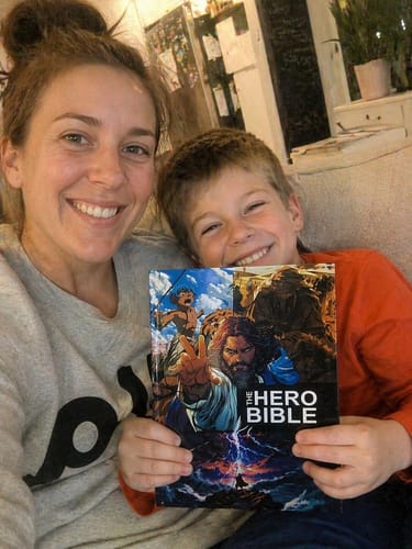 A parent reading The Hero Bible with their family